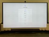a large flat screen tv sitting on top of a wooden stand