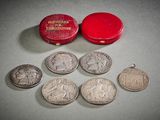 une petite boîte rouge contenant quelques pièces de monnaie