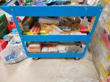 a blue cart filled with various items in a room