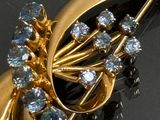 a gold brooch with blue and white stones on it