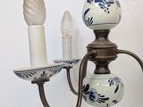 a blue and white vase and a candle holder on a wall