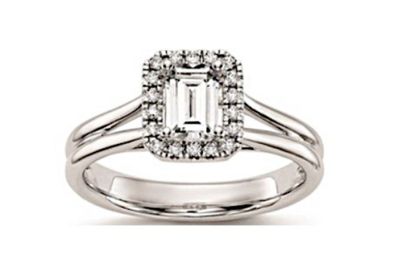 une bague de fiançailles en or blanc sertie d'une émeraude entourée de diamants