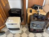 two air purifiers and a heater in the corner of a room