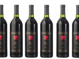 six bottles of red wine are lined up in a row