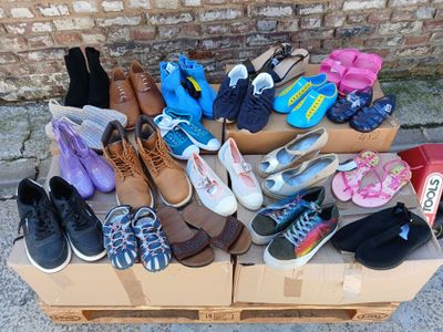 de nombreuses paires de chaussures posées sur une boîte posée par terre