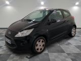 la photo d'une petite voiture noire garée sur un sol en damier