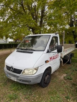 un camion blanc garé sur le bord de la route