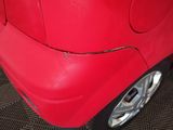 a close up of a red car with holes in it