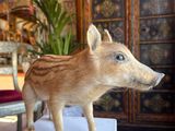 a fake boar standing on a white box in a living room