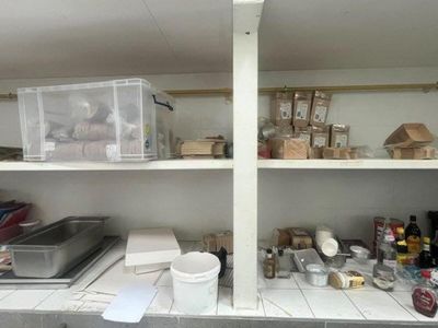 a kitchen with a lot of clutter on the shelves