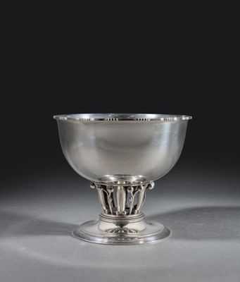 un bol ancien en argent, orné d'un motif décoratif, posé sur un socle