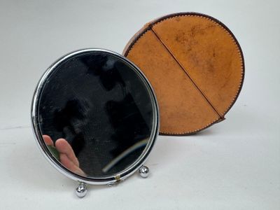 une personne tenant un miroir devant un miroir