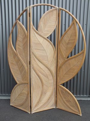 un gros plan sur un paravent en bois orné de feuilles