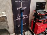 une pancarte indiquant « entreprise de garage » à côté de quelques outils