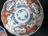 three plates with designs on them are sitting on a black surface