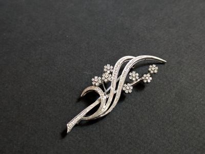 a close up of a brooch with flowers on a black surface
