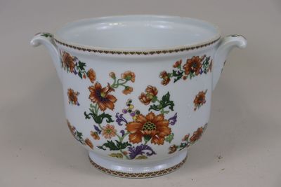 un vase blanc orné de fleurs orange et bleues