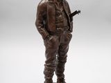 a bronze statue of a man in a cowboy outfit holding a gun