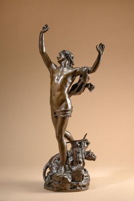 bronze statue of a man on a rock with a cow