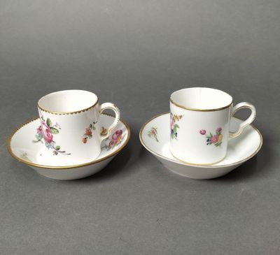 a pair of cups and saucers with floral designs on them