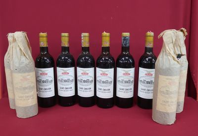 six bottles of wine are lined up in a row on a table