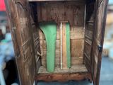 a wooden cabinet with a green vase inside of it