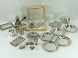 a lot of silver plate and silverware on a table
