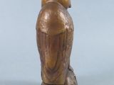 a statue of a bird that is sitting on a tree stump