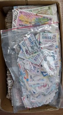 une boîte en carton remplie d'une multitude de billets de toutes sortes