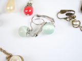 many different types of jewelry displayed on a white surface