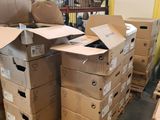 boxes are stacked on pallets in a warehouse with a wire fence in the background
