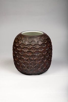 a brown vase that is sitting on a white surface