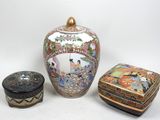 trois vases asiatiques et une boîte posés sur une surface blanche