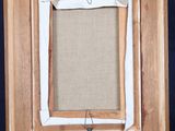 an old wooden easel with a picture frame on top of it