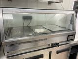 stainless steel counter top with a glass display case in a commercial kitchen