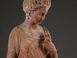 a close up of a statue of a woman with a flower in her hair