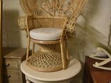 a wicker chair sitting on a small table in a room