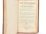 an old book opened to reveal a page of text on a white surface