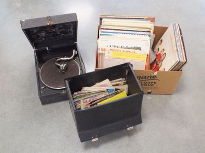 un tourne-disque et une boîte de disques posés par terre