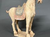 an old statue of a horse with a saddle on it ' s back