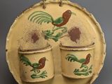 two cups and a saucer on a plate with a rooster design