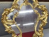 un miroir doré richement décoré posé sur un canapé bleu