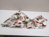a bikini top with tropical print on it sitting on a table