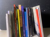 une pile de livres posée sur une table près d'un mur noir