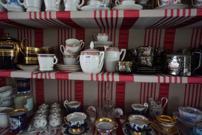 de nombreuses tasses et soucoupes sur les étagères de la pièce