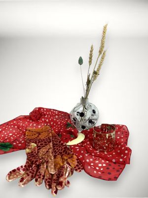 une écharpe rouge et un vase avec des fleurs posés sur une table