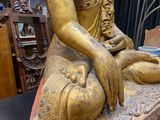 a gold statue of a woman sitting on a table