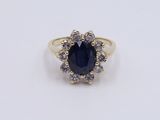 a blue sapphire and diamond ring on a white surface