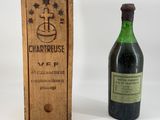 une vieille bouteille de vin posée à côté d'une caisse en bois