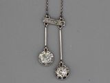 une photo représentant une paire de pendentifs en diamant suspendus à une chaîne